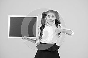 Good news. Schoolgirl pupil long hair informing you. School girl hold blank chalkboard copy space. Announcement and