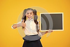 Good news. Schoolgirl pupil long hair informing you. School girl hold blank chalkboard copy space. Announcement and
