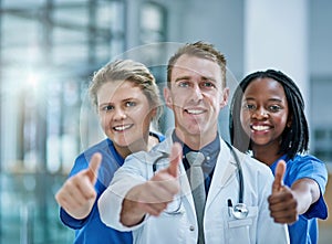 Good news, youre doing great. Portrait of a team of confident young doctors giving thumbs up.