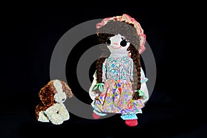 Good Puppy, Sit. Vintage girl rag doll with her puppy; presented on a plain black background.