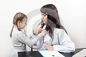 Good relationship with little girl at a doctor`s appointment, communicates with stethoscope playing