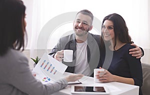 Young millennial couple enjoying coffee, listening to financial advisor photo