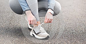 Good shoes makes me a better runner. Cropped shot of a woman tying her shoelaces while out for a run on a road.