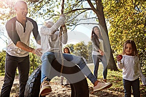 Good, simple swinging fun. a happy father pushing his daughter on a tyre swing.