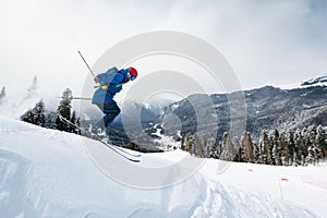 good skiing in snowy mountains. a nice winter day, an incredible ski jump from which a skier jumps against the backdrop