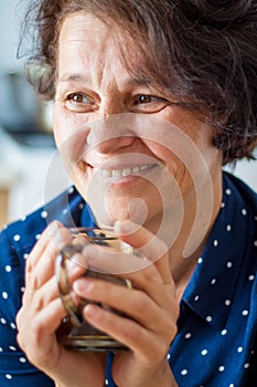 A good stylish middle-aged woman with a cup of coffee. Smiling w