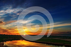 Good sunset in clouds over river