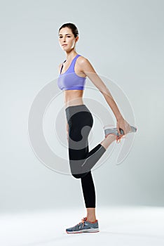 Good things come to those who sweat. Portrait of a beautiful woman stretching against a gray background.