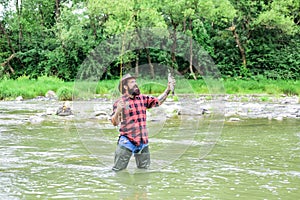 Good things for Good Moments. hobby and sport activity. bearded fisher in water. fisherman show fishing technique use