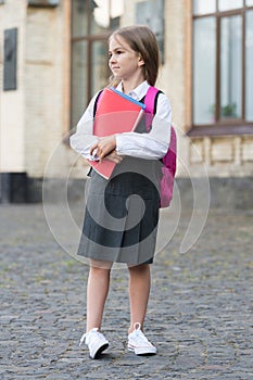 Good things are happening here. Little child go to lyceum school. Lyceum student hold books outdoors. Back to school