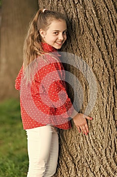 Good vibes only. Girl little cute child enjoy peace and tranquility at tree trunk. Place of power. Peaceful place. Find
