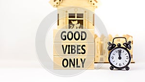 Good vibes only symbol. Concept word Good vibes only on beautiful wooden block. Black alarm clock. Beautiful white table white