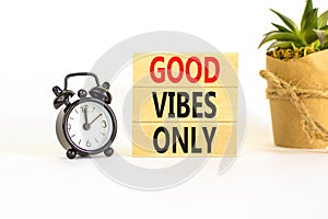 Good vibes only symbol. Concept word Good vibes only on beautiful wooden block. Black alarm clock. Beautiful white table white