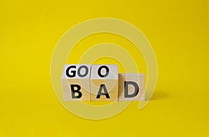 Good vs Bad symbol. Wooden cubes with words Bad and Good. Beautiful yellow background. Business and Good vs Bad concept. Copy