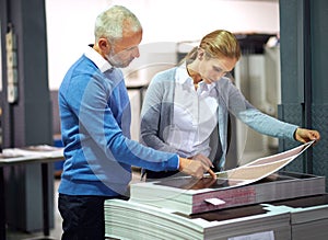 This is good work.... Two publishers assessing the quality of printed work in a factory.