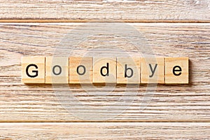 Goodbye word written on wood block. Goodbye text on table, concept