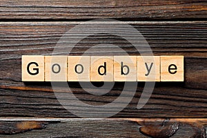 Goodbye word written on wood block. Goodbye text on table, concept