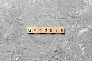 Goodbye word written on wood block. Goodbye text on table, concept