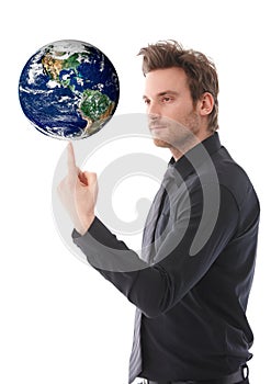 Goodlooking man balancing a globe on forefinger