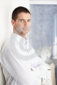 Goodlooking man standing arms crossed