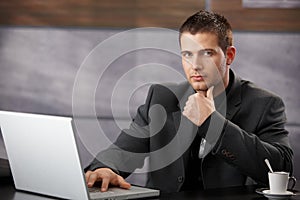 Goodlooking manager sitting at desk in office