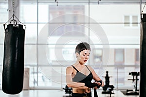 Goodly female changing black bandage in workout