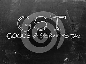 Goods & Services Tax - GST - Handwritten on Blackboard - Stock I