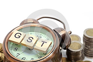 Goods and Services Tax word on Alarm clock and stacks coins