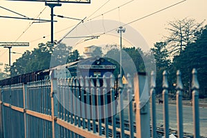 A goods train passing through railway station platform. Diesel locomotive carrying cargo passing through a platform