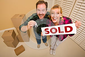 Goofy Couple Holding Keys and Sold Sign Boxes Near photo