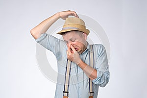 Goofy man in summer hat is worried and shocked because of sweating stain.