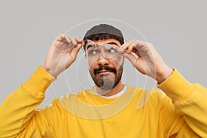 Goofy young man in glasses and yellow sweatshirt