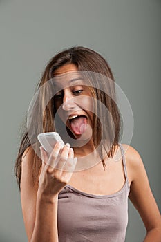 Goofy young woman sticking out her tongue