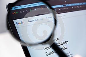 Google Business Profile logo enlarged through a magnifying glass on a laptop screen