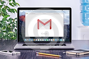 Google Gmail logo on Apple MacBook display in office workplace