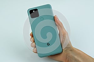 Google Pixel 5 in Sorta Sage color next to its box.