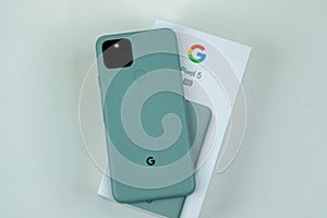 Google Pixel 5 in Sorta Sage color next to its box.