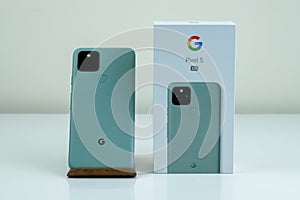 Google Pixel 5 in Sorta Sage color next to its box.
