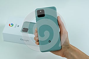 Google Pixel 5 in Sorta Sage color next to its box.