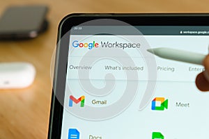 Google Workspace logo shown by apple pencil on the iPad Pro tablet screen. Man using application on the tablet. December