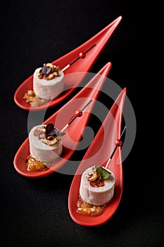 Goose liver pate, foie gras, served on black stone in Japanese red spoons. Paste served with jam and nuts. Fusion food