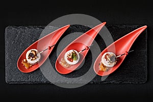 Goose liver pate, foie gras, served on black stone in Japanese red spoons. Paste served with jam and nuts. Fusion food