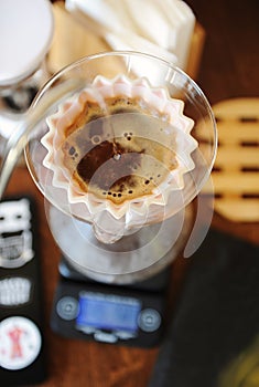 Gooseneck kettle pouring water in pink ceramic origami dripper. Top view. Alternative manual hand coffee brewing