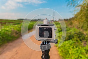 GoPro action camera on stick in dirt road at rural area