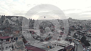 Goreme National park townscape overlooked by hot air ballon at dusk - Fly over Aerial shot