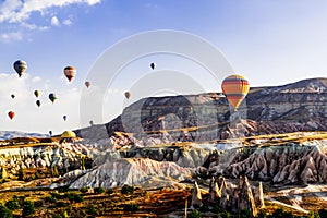 Colorful hot air balloons flying over the valley at Cappadocia, Anatolia, Turkey.