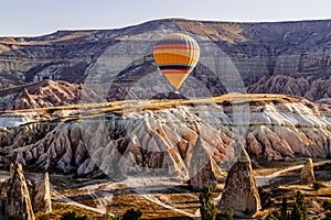 Colorful hot air balloons flying over the valley at Cappadocia, Anatolia, Turkey.