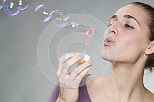 Gorgeous 20's girl blowing soap bubbles for childhood memories