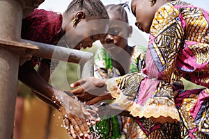 Gorgeous African Girls Washing Hands under Water Tap Outdoors