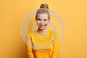 Gorgeous attactive female model posing to the camear over yellow background photo